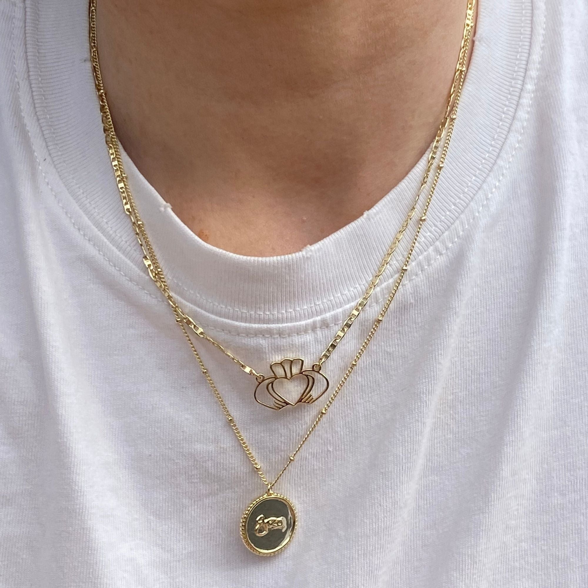 Model wearing Gold Grá Medallion and Have My Heart Claddagh Necklaces