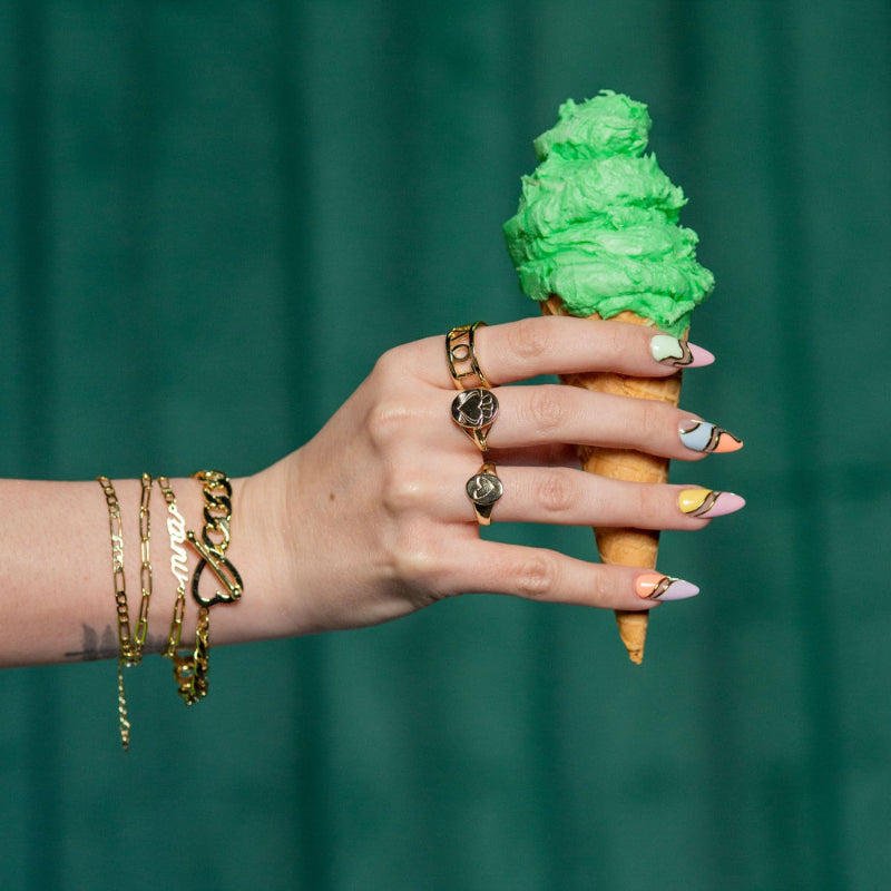 Model Wears Gold Mná Power Necklace on her arm