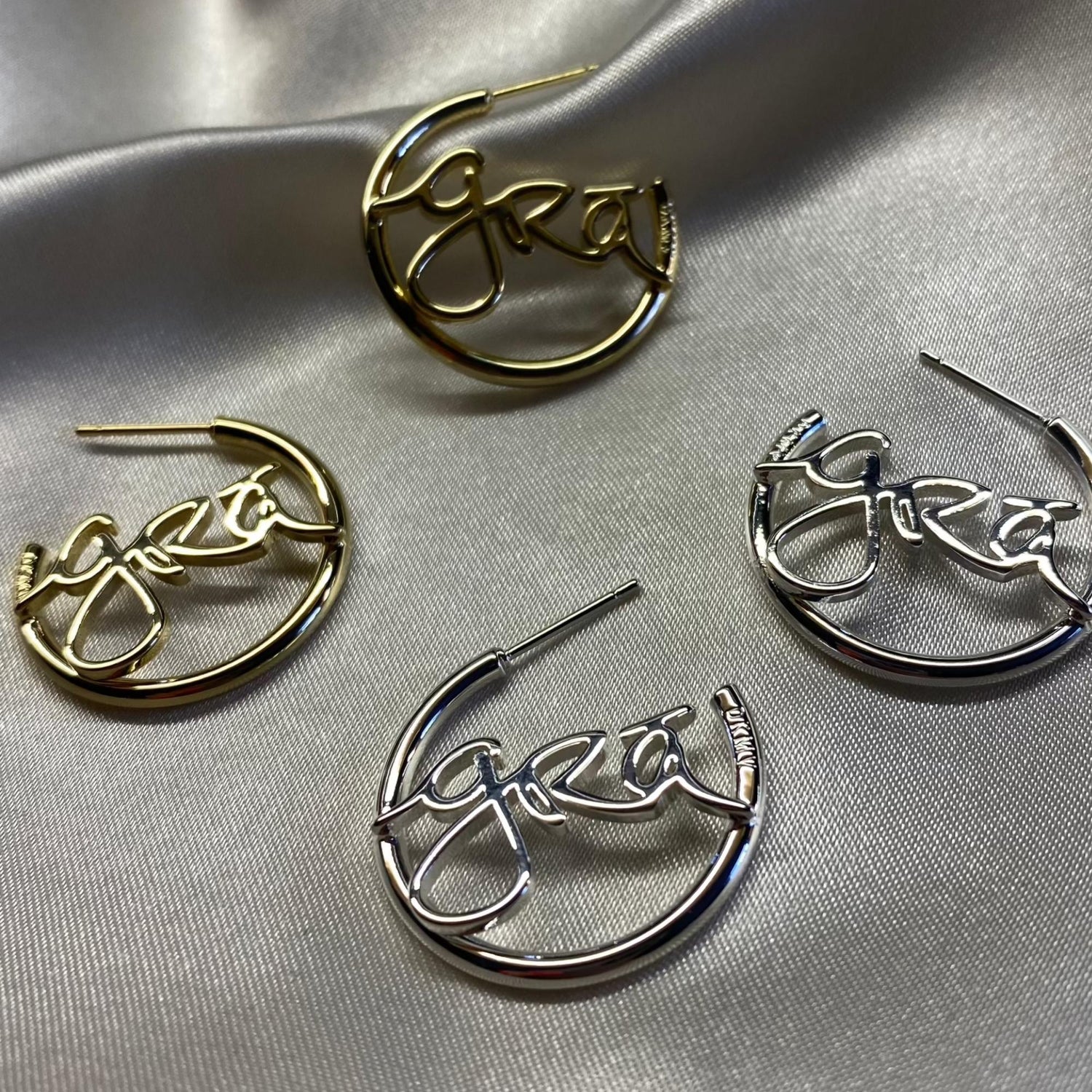 Gold and Silver Grá Beag Hoop Earrings on grey silk