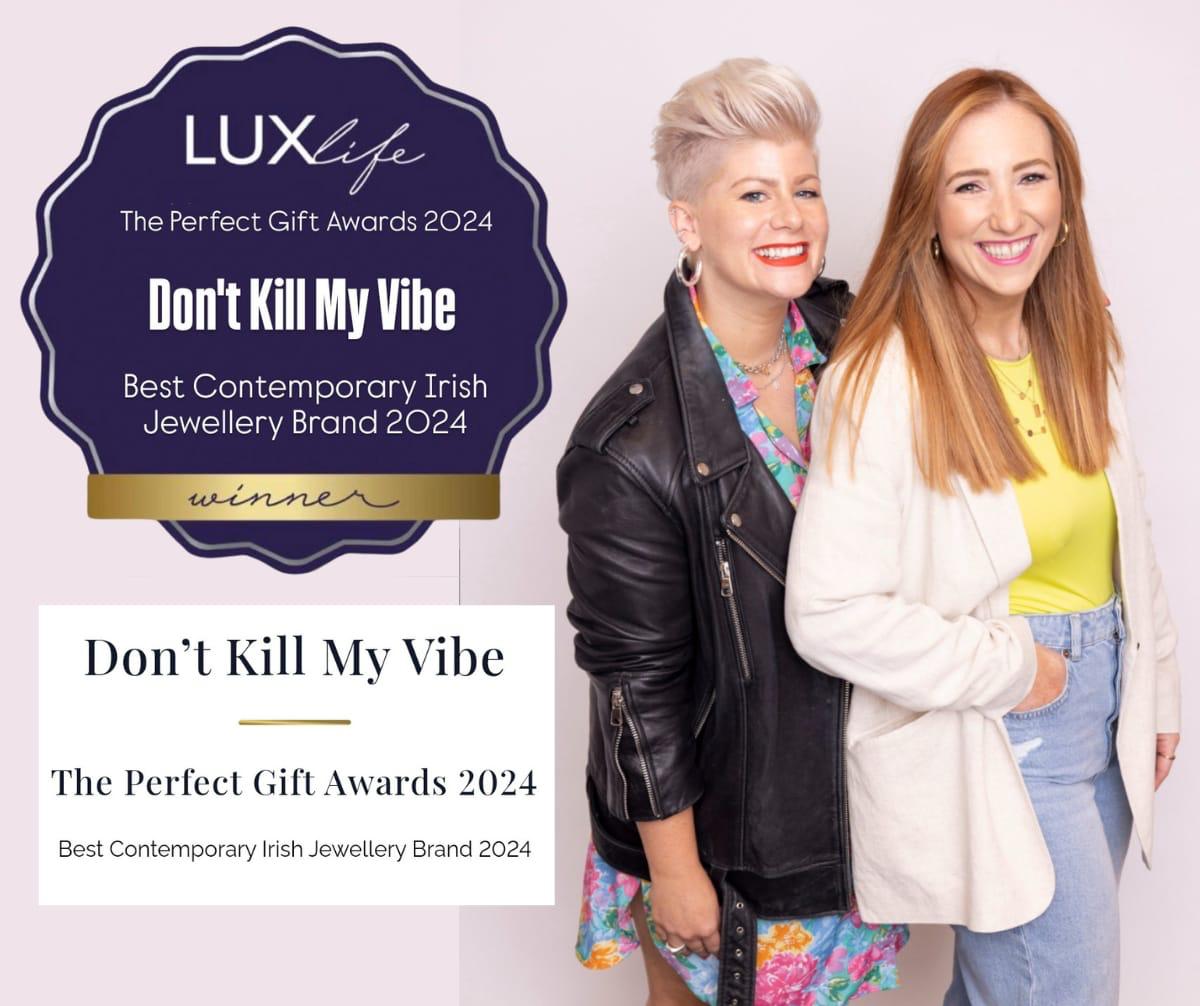Two smiling women posing beside an award graphic reading LuxLife and Dont Kill My Vibe
