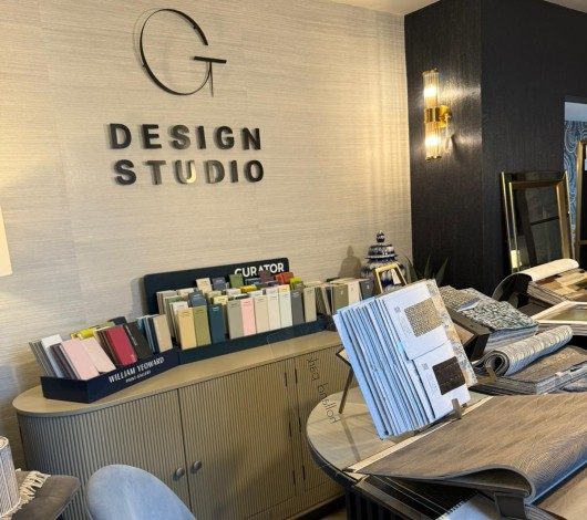 Design studio reception desk with brochures, notebooks, and a wall sign reading Design Studio